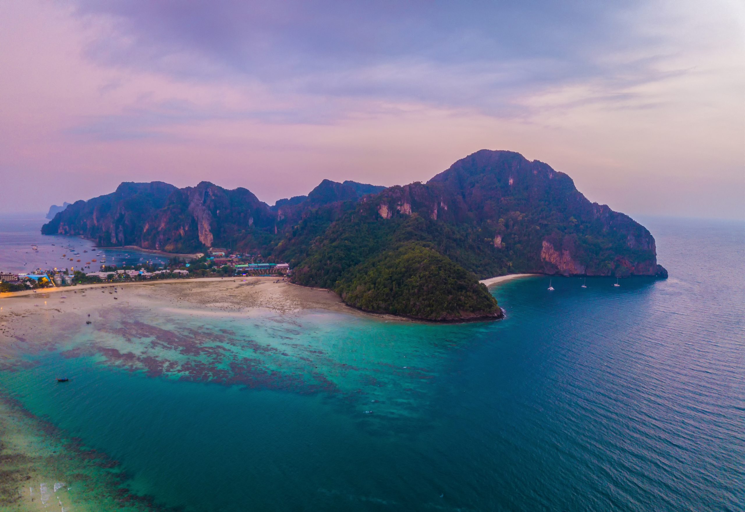 Aerial view of Phi Phi, Maya beach with blue turquoise seawater, mountain hills, and tropical green forest trees at sunset with Andaman sea in Phuket island in summer, Thailand in travel trip. Nature. Aerial view of Phi Phi, Maya beach with blue turquoise seawater, mountain hills, and tropical green forest trees at sunset with Andaman sea in Phuket island in summer, Thailand in travel trip. Nature.